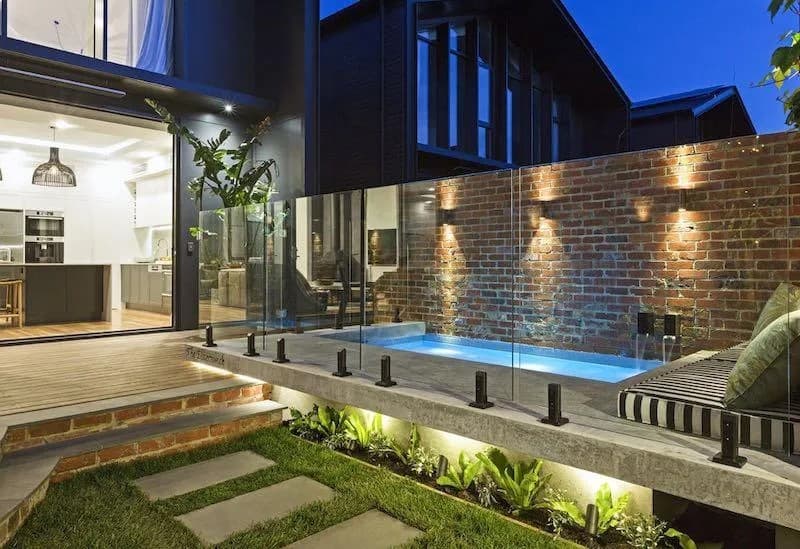 Luxury pool with frameless glass fencing at dusk